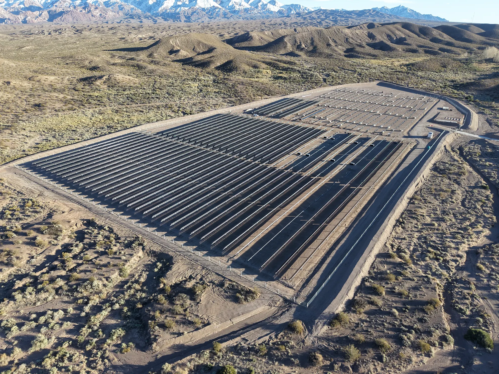 Vista aérea del Parque Solar Uspallata, Mendoza, con la cordillera de los Andes nevada de fondo.